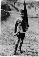 Fotografia Reprodução. Menino com chapéu de chuva ao ombro